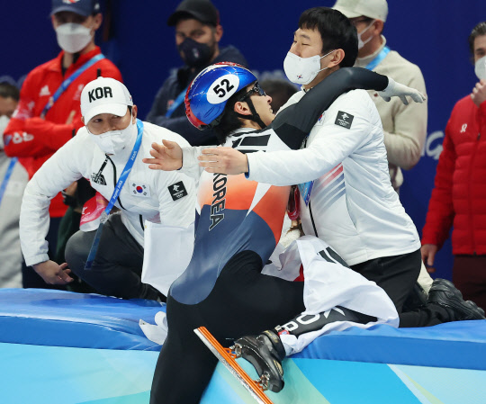 한국 쇼트트랙 대표팀 황대헌이 9일 오후 중국 베이징 캐피털 실내 경기장에서 열린 2022 베이징 동계올림픽 쇼트트랙 남자 1500m 결승전에서 금메달을 딴 뒤 안중혁 코치와 함께 기뻐하고 있다. 왼쪽은 이영석 코치. <베이징=연합뉴스>